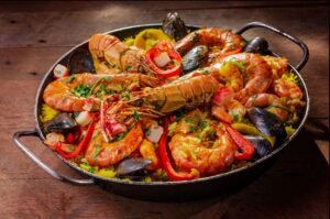 A vibrant and flavorful seafood paella served in a pan with mussels and shrimp.