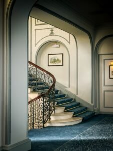 Sophisticated interior with a graceful curved staircase, ornate railing, and classic design accents.