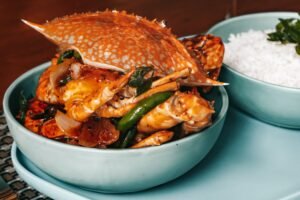 A delectable spicy crab dish paired with rice, perfect for seafood lovers.